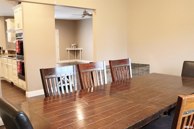 dining room with ceiling fan and dark wood-type flooring