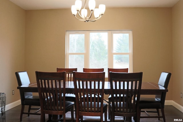 dining area with dark hardwood / wood-style flooring and a notable chandelier