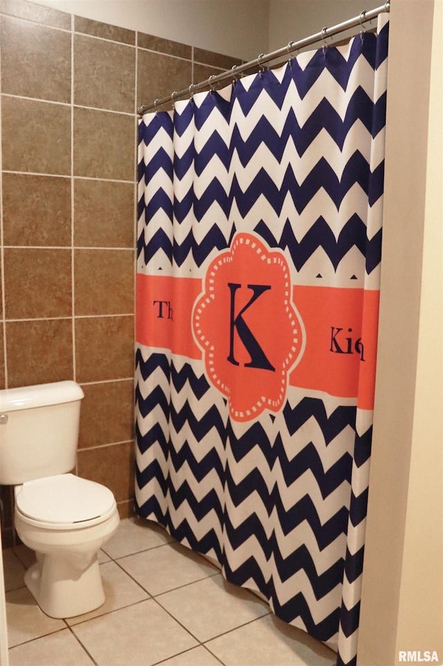 bathroom featuring tile patterned flooring, toilet, tile walls, and walk in shower