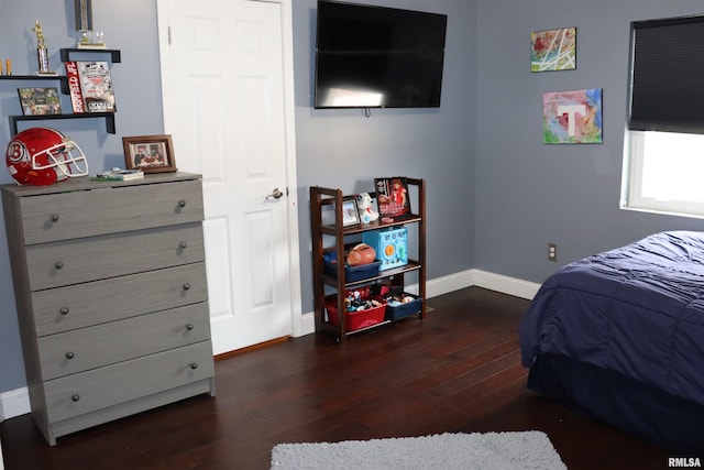 bedroom with dark hardwood / wood-style floors