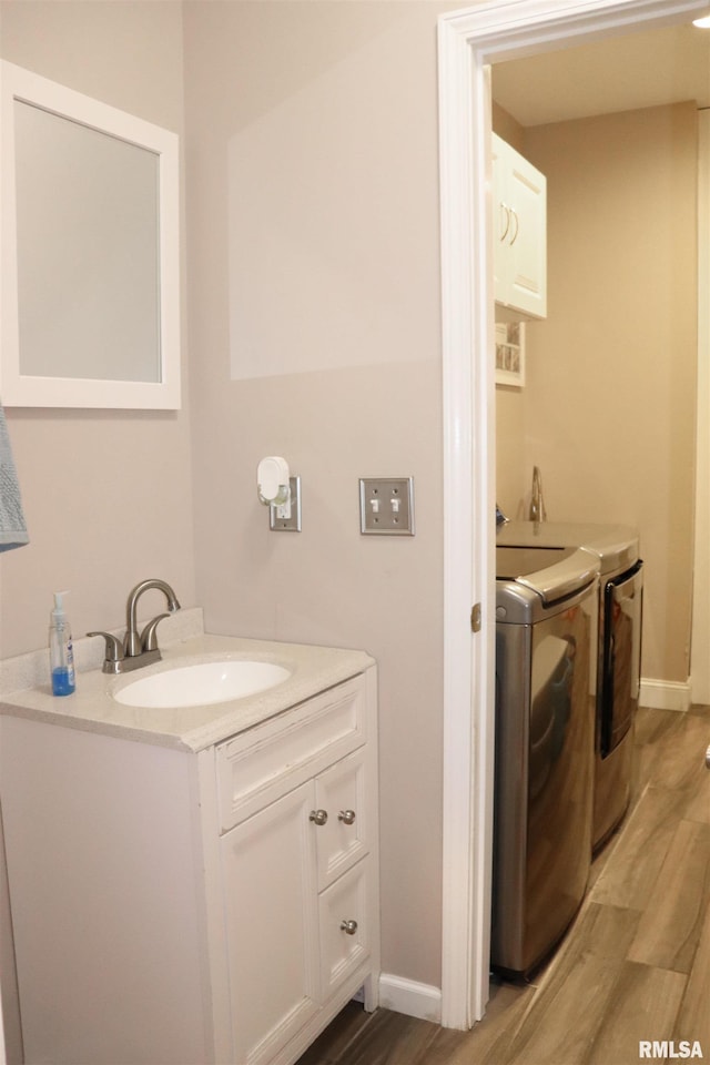 bathroom featuring washing machine and dryer, vanity, and hardwood / wood-style flooring