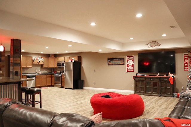 living room with sink and light hardwood / wood-style flooring