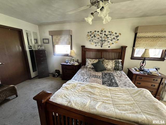 carpeted bedroom with ceiling fan and a textured ceiling