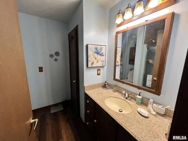 bathroom with hardwood / wood-style floors, vanity, toilet, and a shower