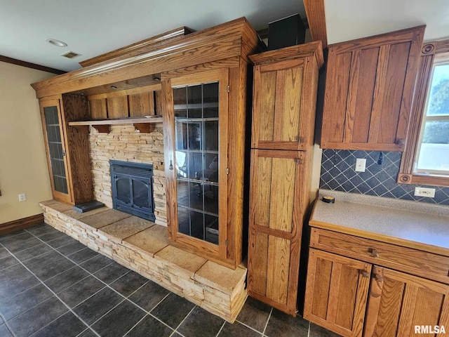 kitchen featuring decorative backsplash, ornamental molding, and a wood stove