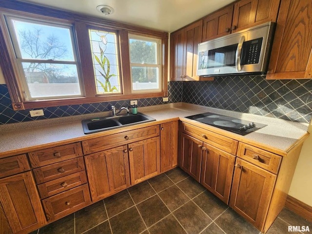 kitchen with black electric cooktop, decorative backsplash, sink, and plenty of natural light