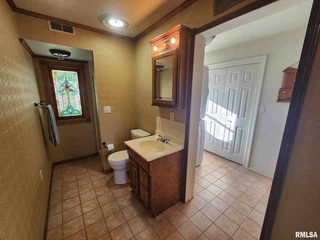 bathroom with tile patterned flooring, vanity, toilet, and ornamental molding