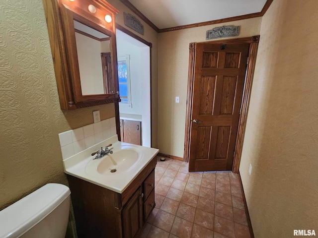 bathroom with vanity, toilet, and crown molding