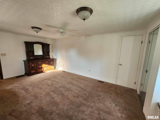 unfurnished living room featuring a textured ceiling, carpet floors, and ceiling fan