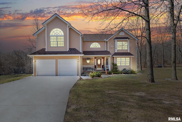 view of front facade with a yard, a porch, and a garage