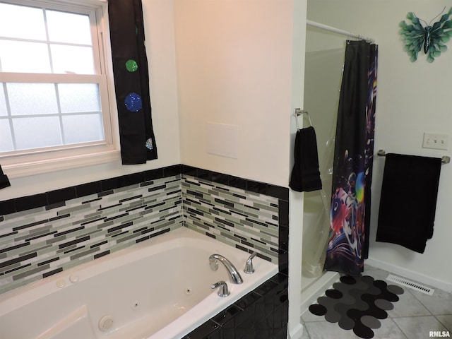 bathroom with tile patterned flooring and a tub to relax in