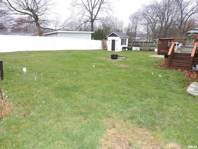 view of yard with a storage shed, an outdoor fire pit, and a wooden deck