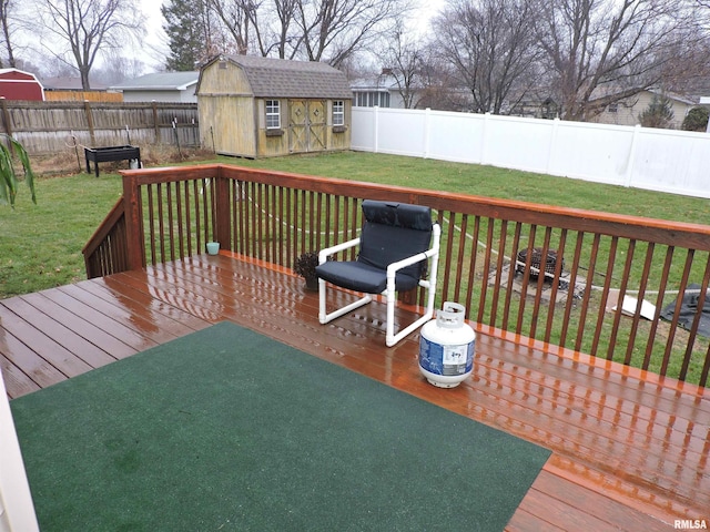 wooden deck featuring a storage unit and a lawn