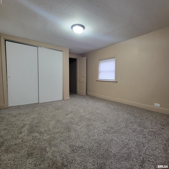 unfurnished bedroom with carpet, a textured ceiling, and a closet