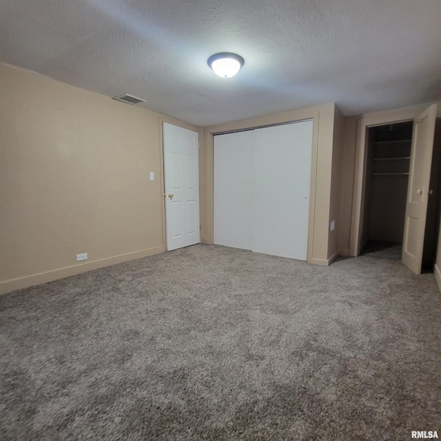 unfurnished bedroom featuring carpet flooring and a textured ceiling