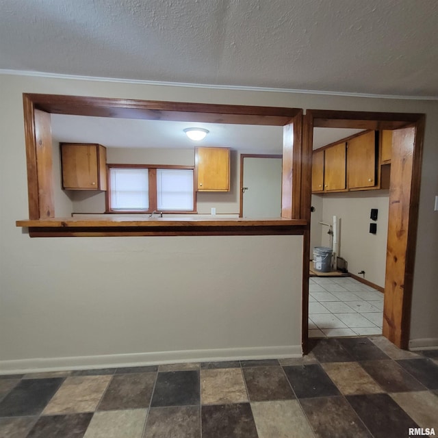 kitchen featuring crown molding and a textured ceiling