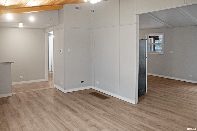 empty room with ceiling fan, hardwood / wood-style floors, and lofted ceiling with beams