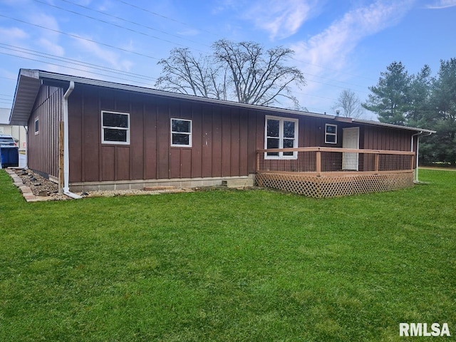 back of property featuring a lawn and a wooden deck