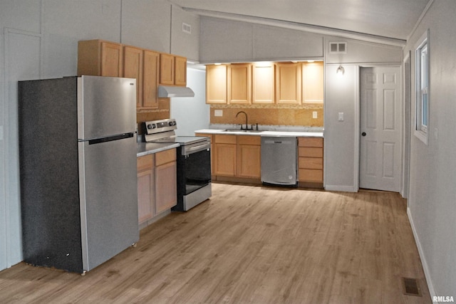 kitchen featuring appliances with stainless steel finishes, light wood-type flooring, lofted ceiling, and sink