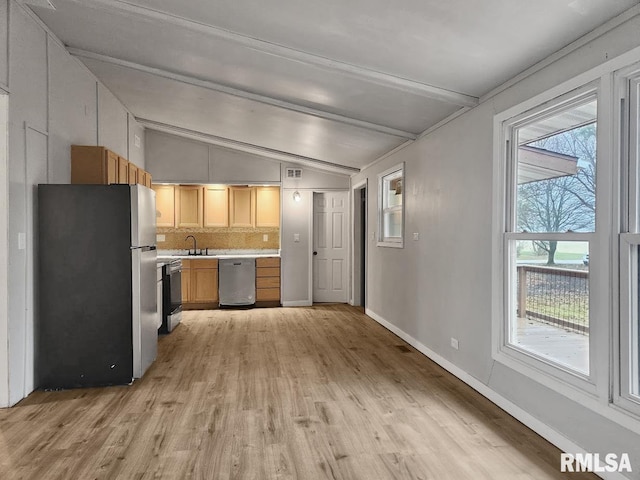 kitchen with backsplash, stainless steel appliances, a healthy amount of sunlight, sink, and vaulted ceiling with beams