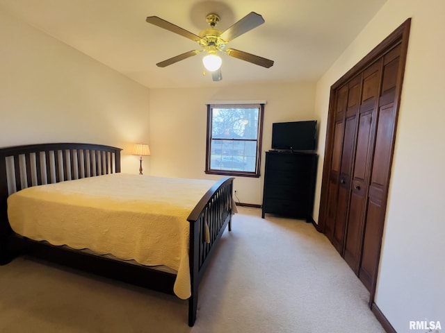 bedroom featuring ceiling fan, light colored carpet, and a closet