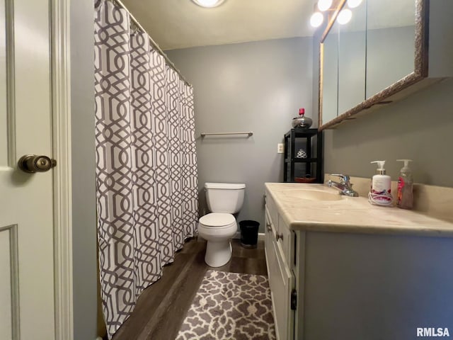 bathroom featuring wood-type flooring, vanity, and toilet