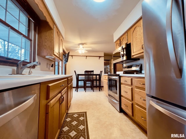 kitchen with ceiling fan, sink, and stainless steel appliances