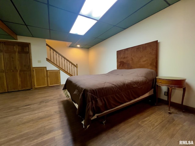 bedroom featuring hardwood / wood-style floors and a drop ceiling