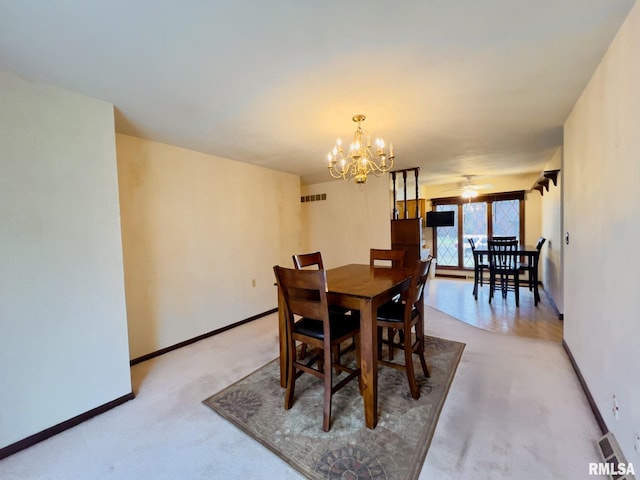 dining room featuring ceiling fan with notable chandelier and light carpet