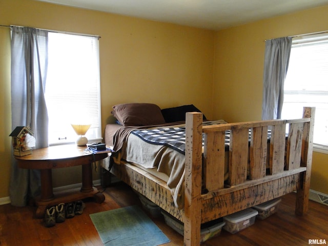 bedroom featuring dark hardwood / wood-style flooring and multiple windows