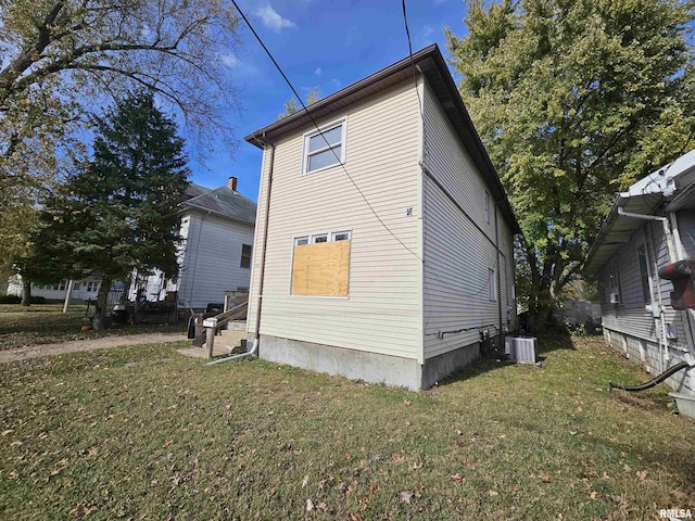 view of property exterior with a yard and central AC unit