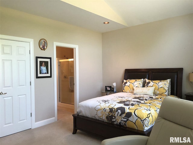 bedroom featuring lofted ceiling, light carpet, and connected bathroom