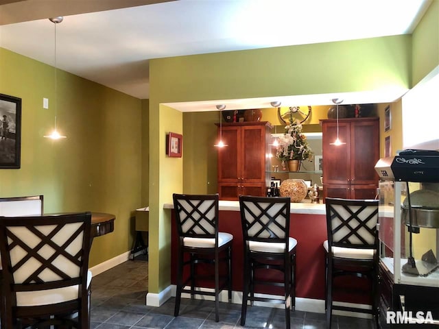 kitchen featuring kitchen peninsula, pendant lighting, and a breakfast bar