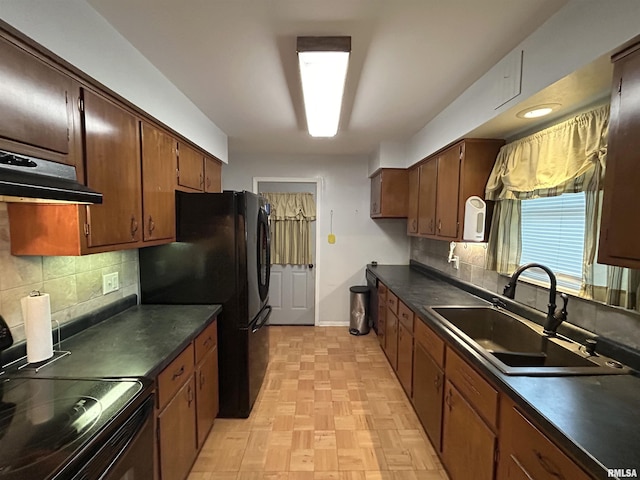 kitchen featuring stove, black fridge, exhaust hood, sink, and light parquet flooring