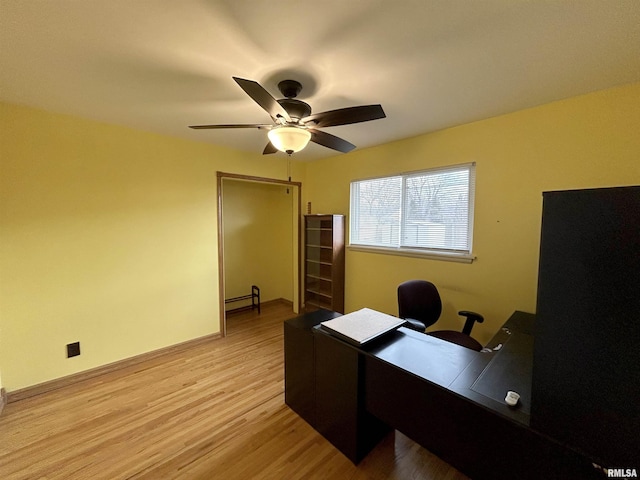 office space with ceiling fan, light hardwood / wood-style floors, and a baseboard heating unit