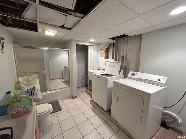 washroom with washing machine and dryer and light tile patterned floors