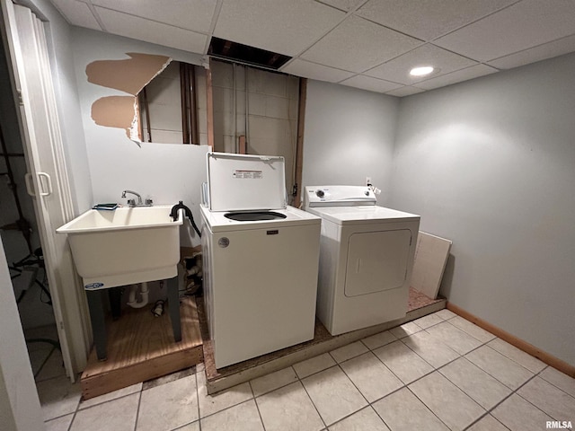 laundry room featuring light tile patterned floors, sink, and washing machine and clothes dryer