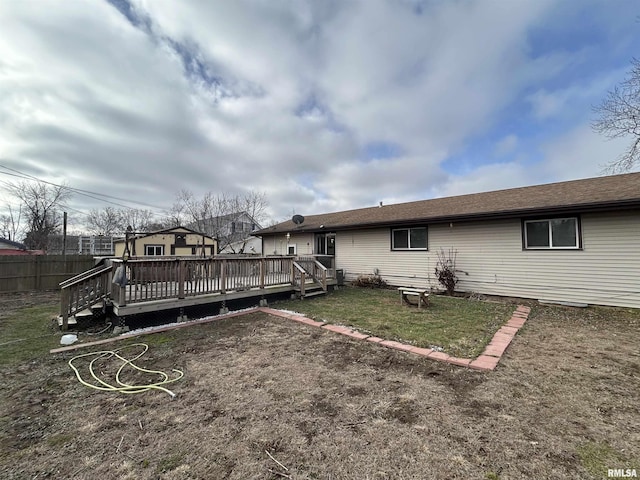 rear view of house featuring a yard and a wooden deck