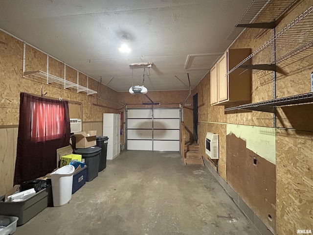 garage featuring heating unit, wood walls, and a garage door opener