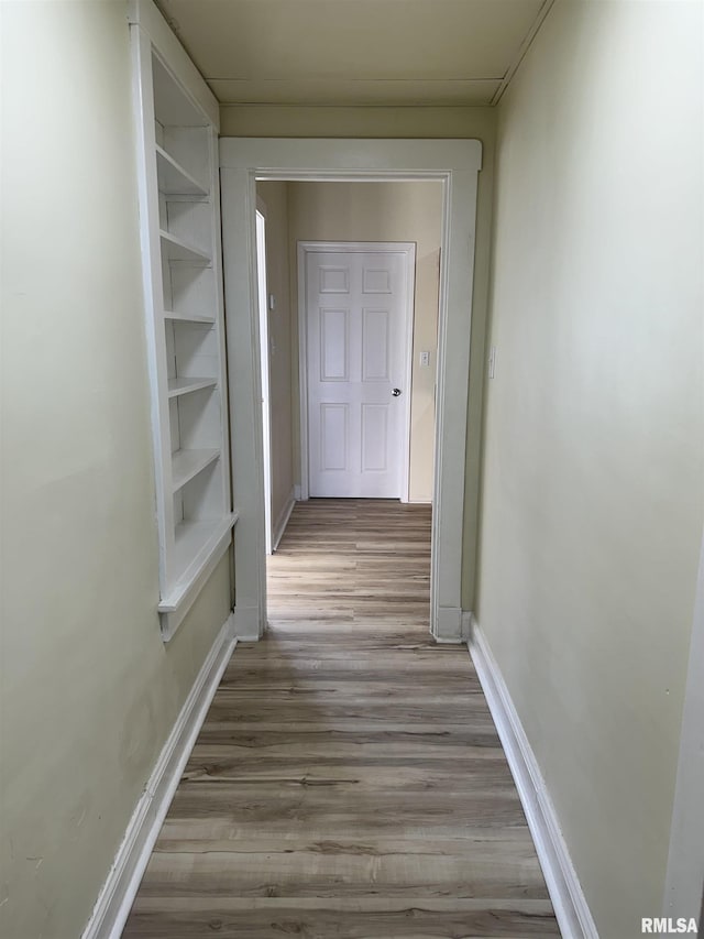 hall with built in features and light wood-type flooring