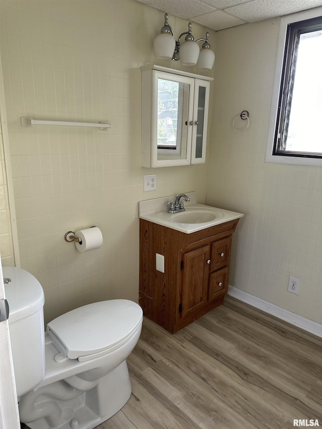 bathroom with vanity, hardwood / wood-style flooring, toilet, and a drop ceiling