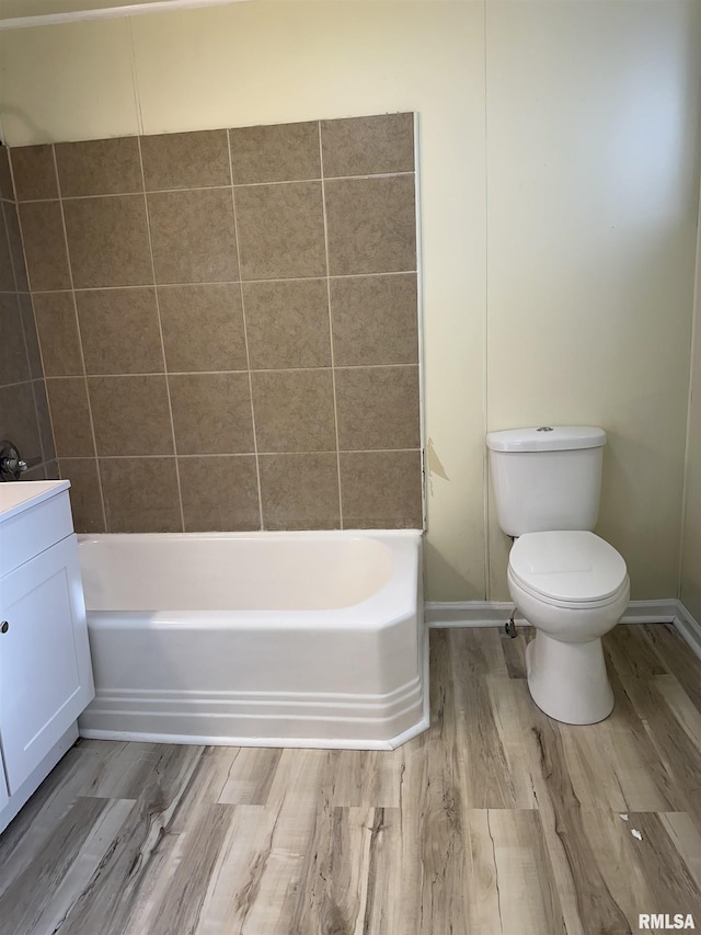 full bathroom with vanity, hardwood / wood-style flooring, toilet, and tiled shower / bath combo