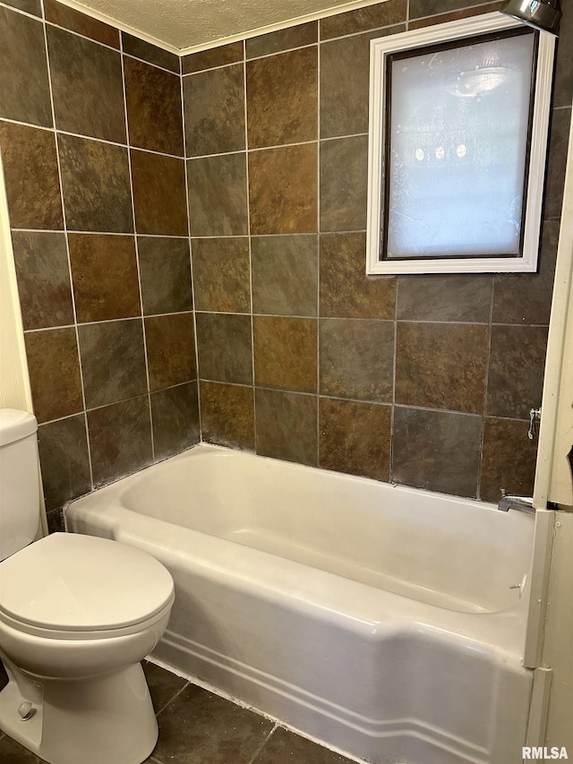 bathroom with tile patterned floors,  shower combination, toilet, and a textured ceiling