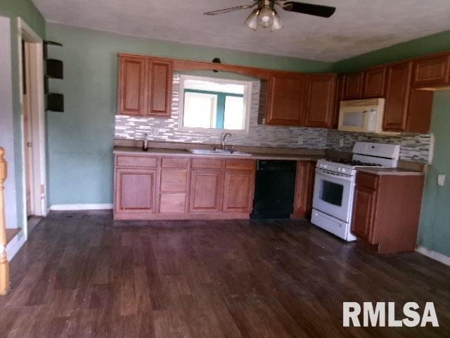 kitchen featuring white appliances, sink, dark hardwood / wood-style floors, ceiling fan, and tasteful backsplash