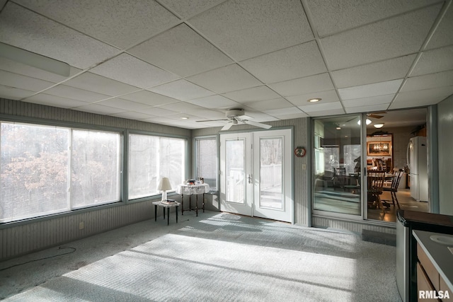 unfurnished sunroom featuring a paneled ceiling, ceiling fan, and plenty of natural light