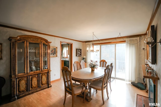 dining area featuring a notable chandelier, light hardwood / wood-style floors, and crown molding