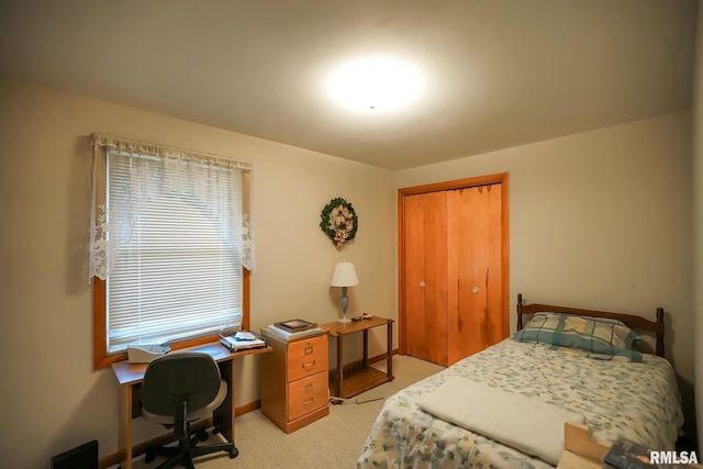 bedroom featuring light colored carpet and a closet