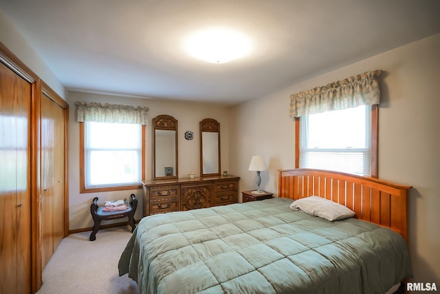 bedroom with light carpet and multiple windows