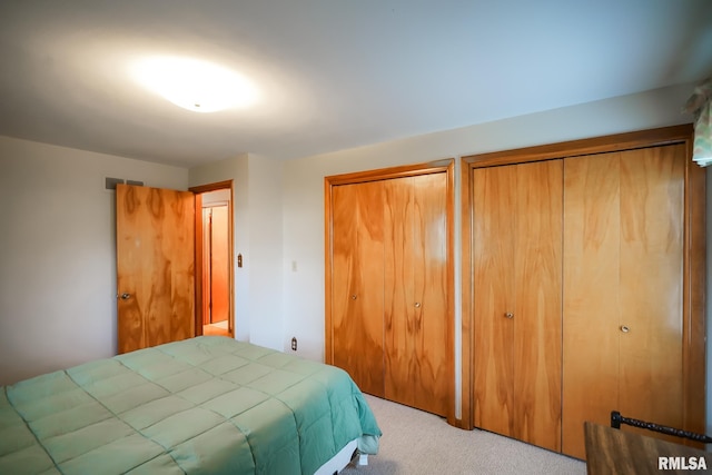 carpeted bedroom featuring two closets