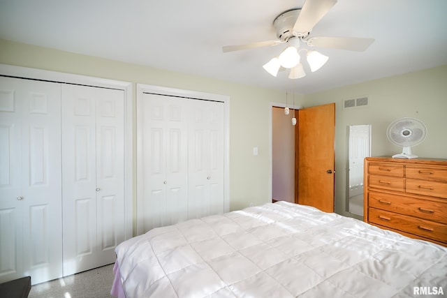 bedroom with ceiling fan and multiple closets